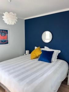 a blue bedroom with a large bed with colorful pillows at Les Pierres Marines in Le Conquet