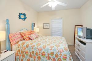 a bedroom with a bed and a flat screen tv at Dunes Club 1C by Pristine Properties Vacation Rentals in Cape San Blas +25 photos