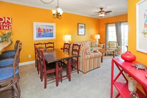 a dining room and living room with orange walls at Dunes Club 1C by Pristine Properties Vacation Rentals in Cape San Blas