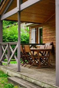 a wooden deck with a table and chairs on a cabin at Camping Les Aubazines in Bort-les-Orgues