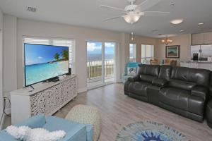 a living room with a couch and a flat screen tv at Surfside 16 by Pristine Properties Vacation Rentals in Mexico Beach