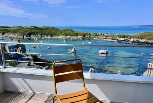 a chair on a balcony with a view of a harbor at Les Pierres Marines in Le Conquet