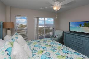 a bedroom with a bed and a flat screen tv at Surfside 16 by Pristine Properties Vacation Rentals in Mexico Beach