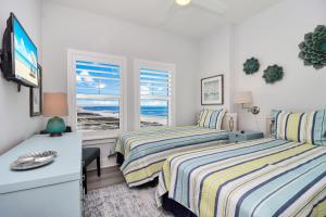 a bedroom with two beds and a tv and a window at The Vue 2C by Pristine Properties Vacation Rentals in Mexico Beach +54 photos