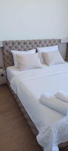 a large white bed with white sheets and pillows at Belgrade Waterfront Sole in Sajmište