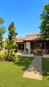 a house with a wooden walkway in the yard at Le Maquis Plage Corse in Poggio-Mezzana