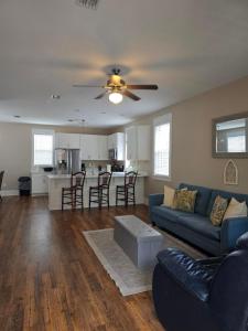 a living room with a blue couch and a kitchen at Barefoot Cottage B37 by Pristine Properties in Highland View