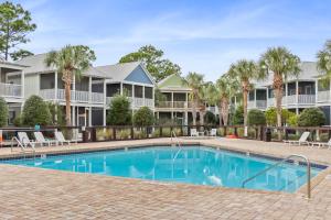 a swimming pool with palm trees and houses at Barefoot Cottage B37 by Pristine Properties in Highland View
