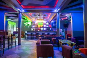 a bar with purple and green lighting in a restaurant at Legacy Chillout Kasese in Kasese