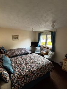 a hotel room with two beds and a window at Hamilton House Guest House in Oban +25 photos
