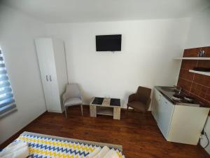 a kitchen with two chairs and a table in a room at Pavle Petra apartments in Mitrovići