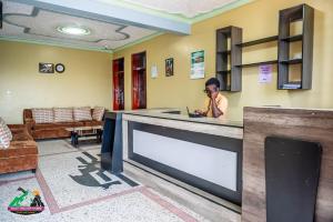 a woman talking on a cell phone in a waiting room at Legacy Chillout Kasese in Kasese +98 photos