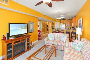 a living room with yellow walls and a flat screen tv at Dunes Club 1C by Pristine Properties Vacation Rentals in Cape San Blas
