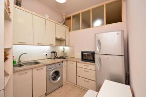 a kitchen with white cabinets and a refrigerator at The Best Apartment in Yerevan