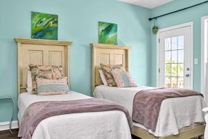 two beds in a room with blue walls at Rehoboth Cottage by Pristine Properties Vacation Rentals in Indian Pass +44 photos