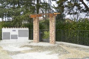 un cancello con due montanti di fronte a una recinzione di Dolce Casetta a Faenza