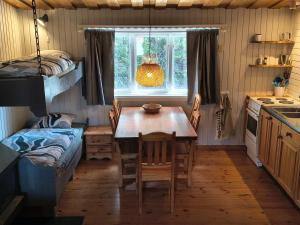 a kitchen and dining room with a table and a bed at Lilla Åsbo Gård in Husvallsgölen