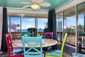 a table and chairs on a screened porch with the ocean at Sea Shell by Pristine Properties Vacation Rentals in Mexico Beach