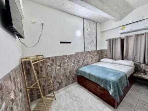 a room with a bed and a tv and a ladder at LUA origenes Alojamiento FIRST FLOOR in Santa Marta +10 photos