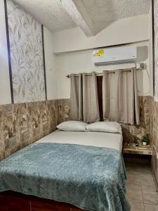 a bedroom with a large bed with avertisement at LUA origenes Alojamiento FIRST FLOOR in Santa Marta
