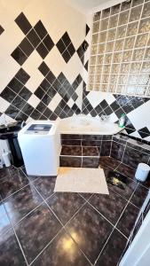 a bathroom with a tub and a tile wall at Phumula Home in Mbabane +12 photos