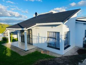 a white house with a black roof at Phumula Home in Mbabane