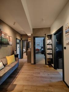 a living room with a blue couch and a hallway at Scuderia Split Rooms in Split