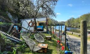 a group of chairs and tables next to a river at Chambre d'hôtes dans maison éclusière in Hennebont