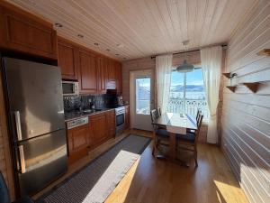 a kitchen with a table and a refrigerator at Kilpis-Silent Apartment in Kilpisjärvi