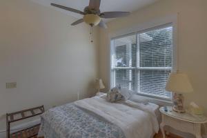 a bedroom with a bed with a ceiling fan and a window at Camp Palms @ Indian Pass by Pristine Properties Vacation Rentals in Indian Pass