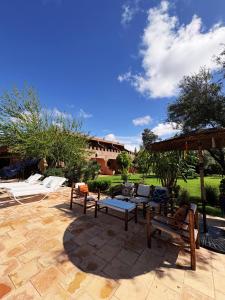 a patio with chairs and tables and an umbrella at Palais Riad Berbère in Marrakesh