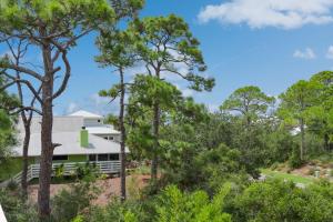 a house in the woods with trees at Woofs and Waves by Pristine Properties Vacation Rentals in Cape San Blas