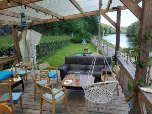 a patio with a couch and chairs and a table at Chambre d'hôtes dans maison éclusière in Hennebont