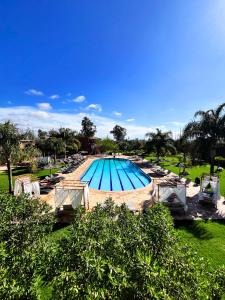 a large swimming pool with lounge chairs and sidx sidx sidx at Palais Riad Berbère in Marrakesh