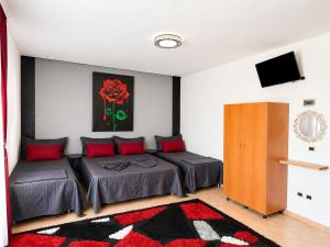 a bedroom with two beds with red pillows at Hotel Bar Restaurant MANI in Velipojë