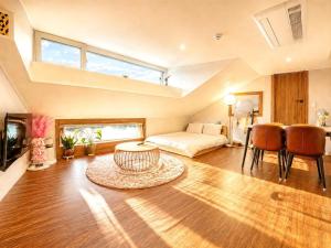 a large living room with a bed and a table at Chuncheon Kerensia Pension in Chuncheon