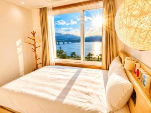 a bedroom with a bed and a large window at Chuncheon Kerensia Pension in Chuncheon