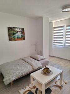 a white room with a bed and a table at Studio apartment Cascada in Plitvička Jezera