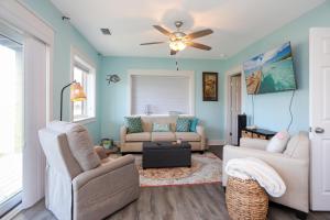 a living room with a couch and a ceiling fan at Beach View Lower by Pristine Properties Vacation Rentals in Mexico Beach