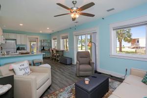 a living room with blue walls and a ceiling fan at Beach View Lower by Pristine Properties Vacation Rentals in Mexico Beach