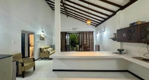 a kitchen and living room with a table and chairs at Induruwa Cottage in Induruwa