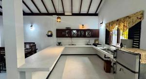 a large white room with a counter and a sink at Induruwa Cottage in Induruwa