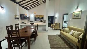 a kitchen and living room with a table and a couch at Induruwa Cottage in Induruwa +9 photos
