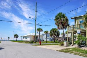 a street with houses and palm trees and a red fire hydrant at Beach View Upper by Pristine Properties Vacation Rentals in Mexico Beach +18 photos