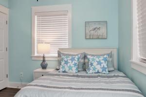 a bedroom with a bed with blue walls and a window at Beach View Upper by Pristine Properties Vacation Rentals in Mexico Beach
