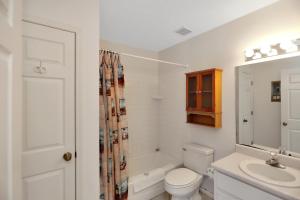 a white bathroom with a toilet and a sink at DeLight House by Pristine Properties Vacation Rentals in Indian Pass +38 photos