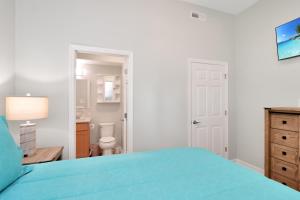 a bedroom with a blue bed and a bathroom at Dolphin Daze Hideaway by Pristine Properties Vacation Rentals in Saint Joe Beach
