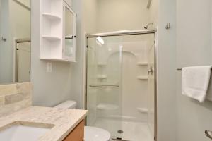 a bathroom with a shower and a toilet and a sink at Dolphin Daze Hideaway by Pristine Properties Vacation Rentals in Saint Joe Beach +28 photos
