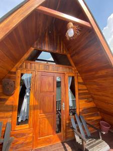 a cabin with a wooden door and two chairs at Banyu 2 in Palayangan