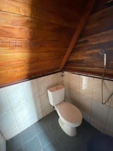 a toilet in a bathroom with a wooden ceiling at Banyu 2 in Palayangan